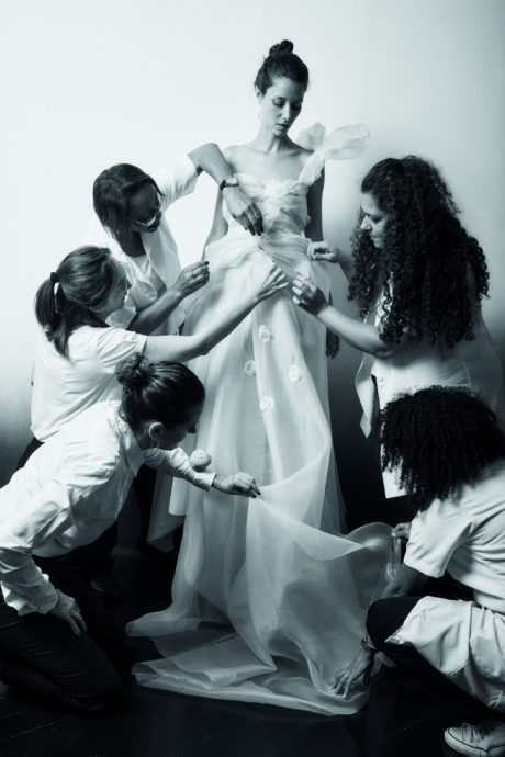 Emanuelle Junqueira e com sua equipe ajustando um vestido de noiva. Foto:. Marcio Simmch