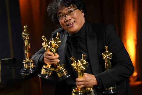 O cineasta Bong Joon Ho com suas estatuetas do Oscar (foto Valerie Macon / AFP)