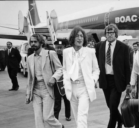 'Magic Alex', de bolsa a tiracolo ao lado de John Lennon, em uma de muitas viagens com os Beatles.